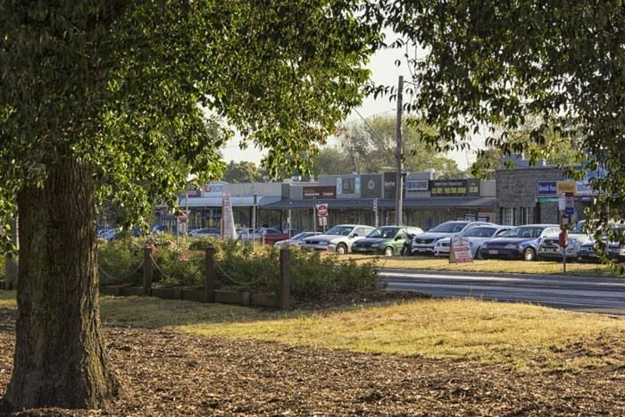 Street-level view of shops along Wallan's main shopping strip on a sunny afternoon