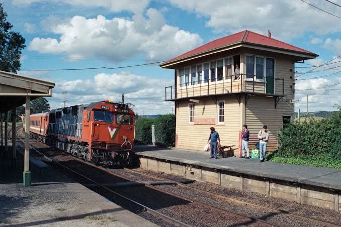 Historic photograph of a V/Line train arriving at Wallan railway station with passengers waiting on the platform